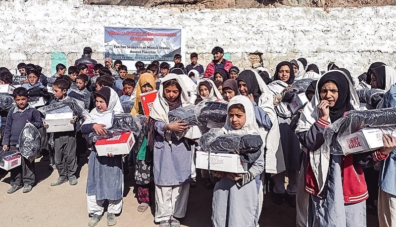 Schoolchildren in Askole hold warm clothes donated by Alex Găvan Foundation. — Photo by author