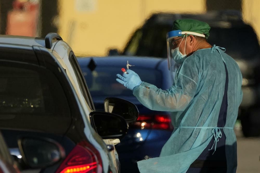 A healthcare worker tests people for Covid-19 at a drive-up testing centre at Tropical Park, Miami, US, Dec 29. — AP