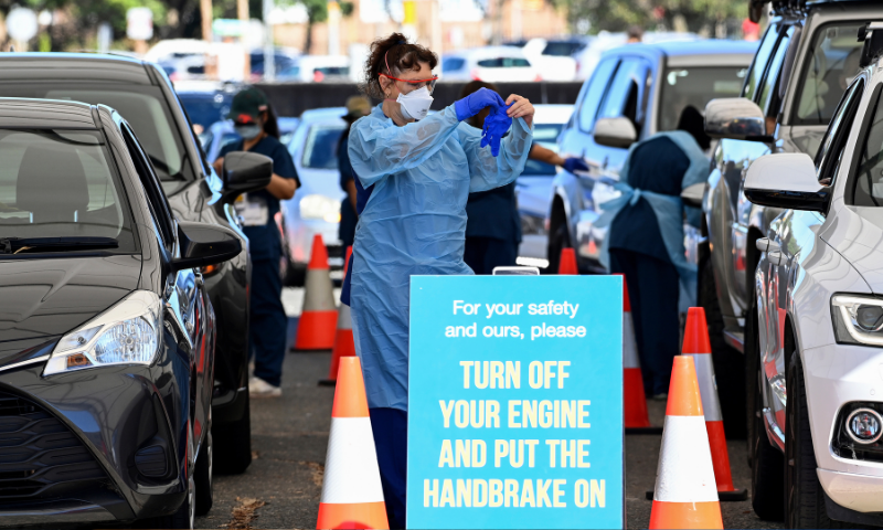 Healthcare workers administer Covid-19 tests at a drive-through clinic in Sydney on Friday. &mdash; AP