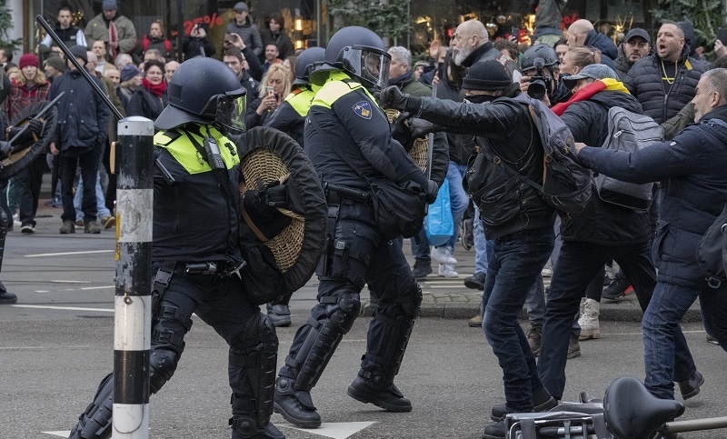 Dutch riot police beat a protestor during small clashes as thousands of people defied a ban to gather and protest the Dutch government's coronavirus lockdown measures, in Amsterdam, Netherlands, on Sunday. — AP