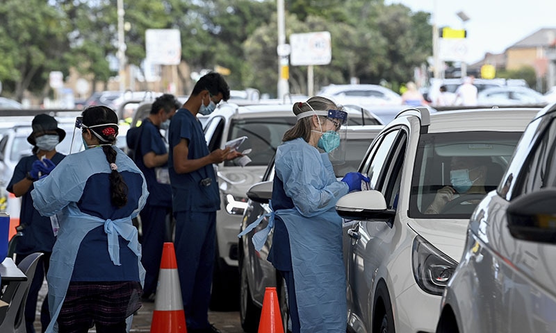 Healthcare workers administer Covid-19 PCR tests at the St Vincent's Drive-through Clinic at Bondi Beach in Sydney. &mdash; AP