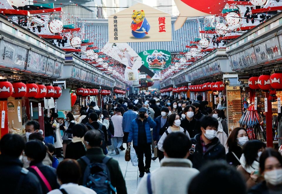 Visitors wearing protective face masks walk under decorations for the New Year at Nakamise street leading to Senso-ji temple at Asakusa district in Tokyo, Japan, December 24. — Reuters