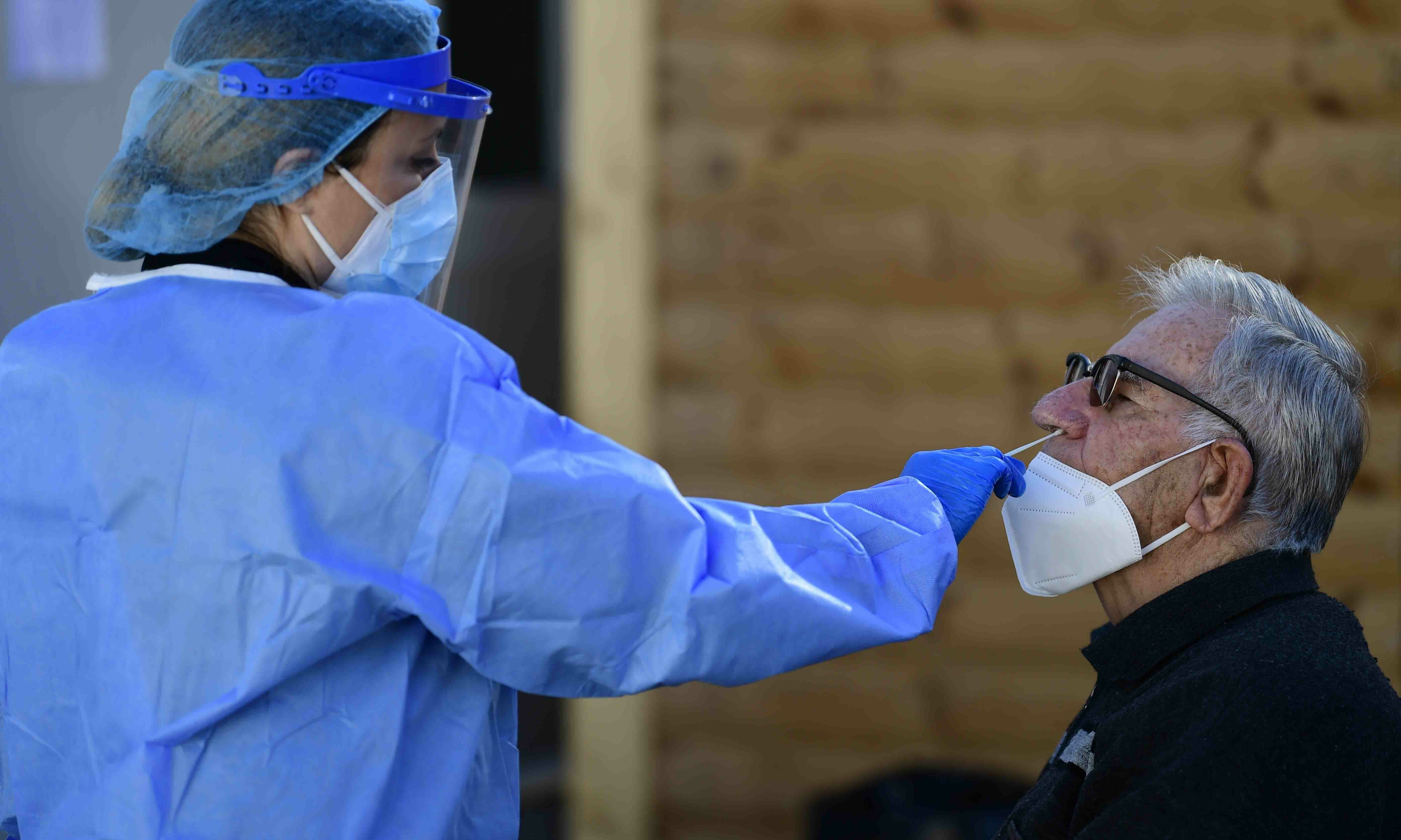 A medical staff conducts a Covid-19 rapid test on a man in Athens on January 4. — AP