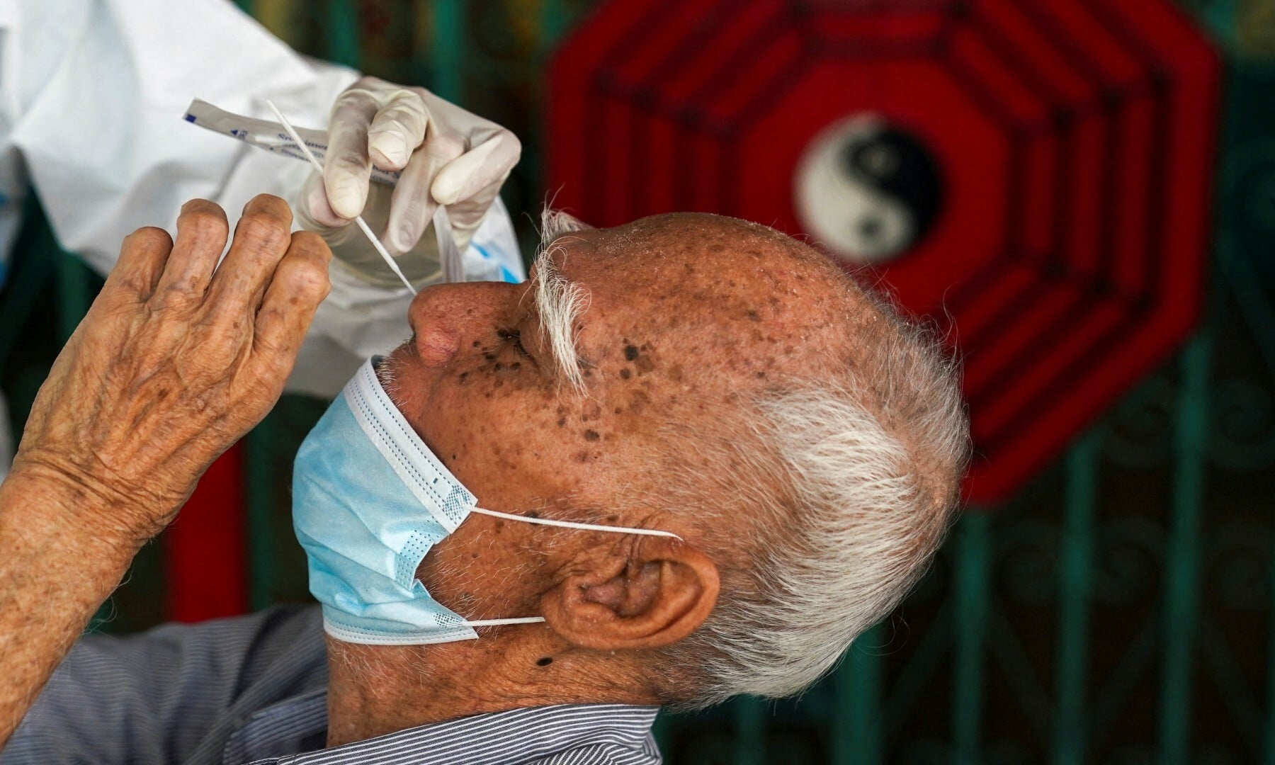 A health worker from Zendai organisation in personal protective equipment takes a swab sample from a man for a rapid antigen test amid the coronavirus disease outbreak in Bangkok on Jan 5. — Reuters