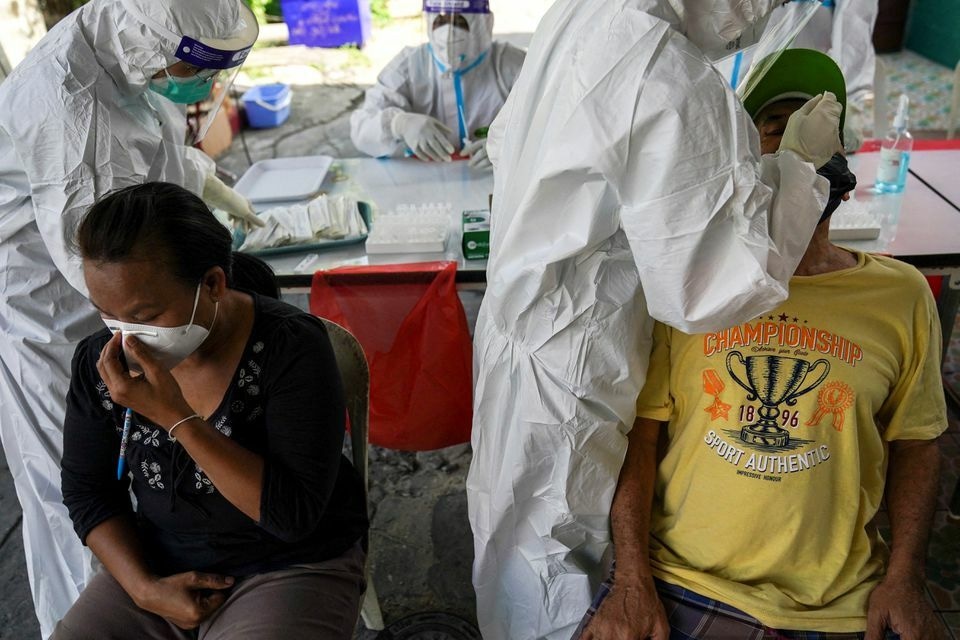 Health workers from Zendai organisation in personal protective equipment take swab samples from people for a rapid antigen test amid the coronavirus outbreak, in Bangkok, Thailand, January 5. — Reuters