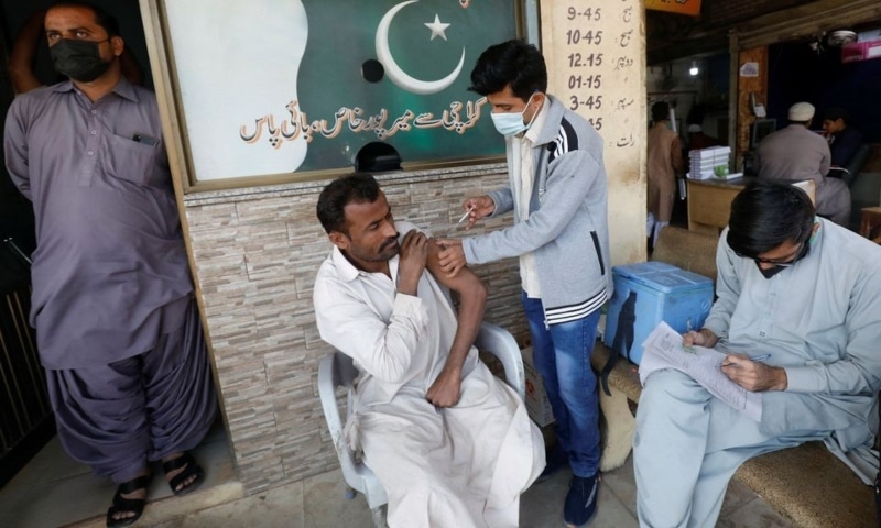 A man receives a dose of the coronavirus disease vaccine at a market in Karachi, December 16. — Reuters