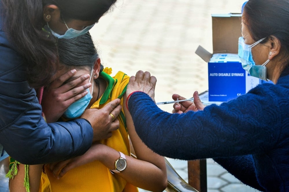 A health worker inoculates a schoolgirl with the Moderna Covid-19 coronavirus vaccine at a school in Bhaktapur, on the outskirts of Kathmandu, on January 10. — AFP