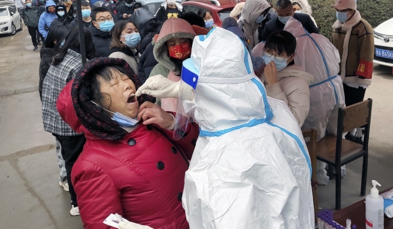 A medical worker wearing a protective suit takes swab samples for the Covid-19 test on residents in Huaxian county in central China's Henan province on Monday. — AFP