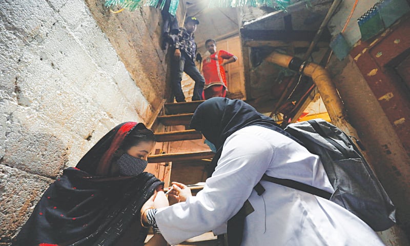 KARACHI: A healthcare worker administers a Covid-19 vaccine dose during a door-to-door campaign in a slum on Thursday.—Reuters