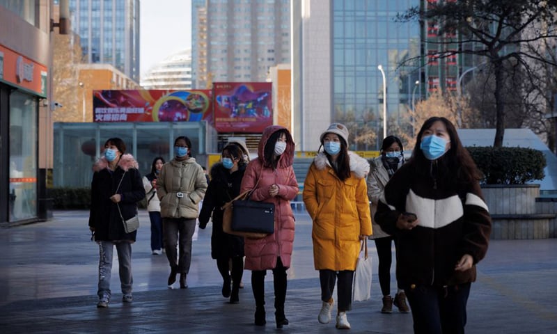 People walk in a street as the Covid-19 outbreak continues in Beijing, China. — Reuters/File