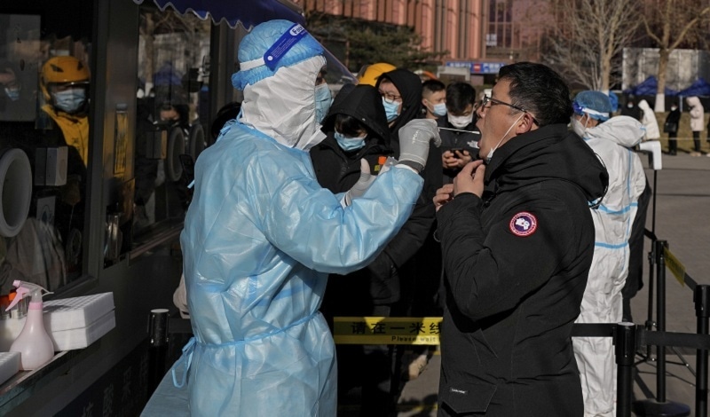 A man gets a nasal swab for the Covid-19 test to meet travelling requirements at a mobile coronavirus testing facility outside a commercial office building in Beijing on Sunday. &mdash; Reuters