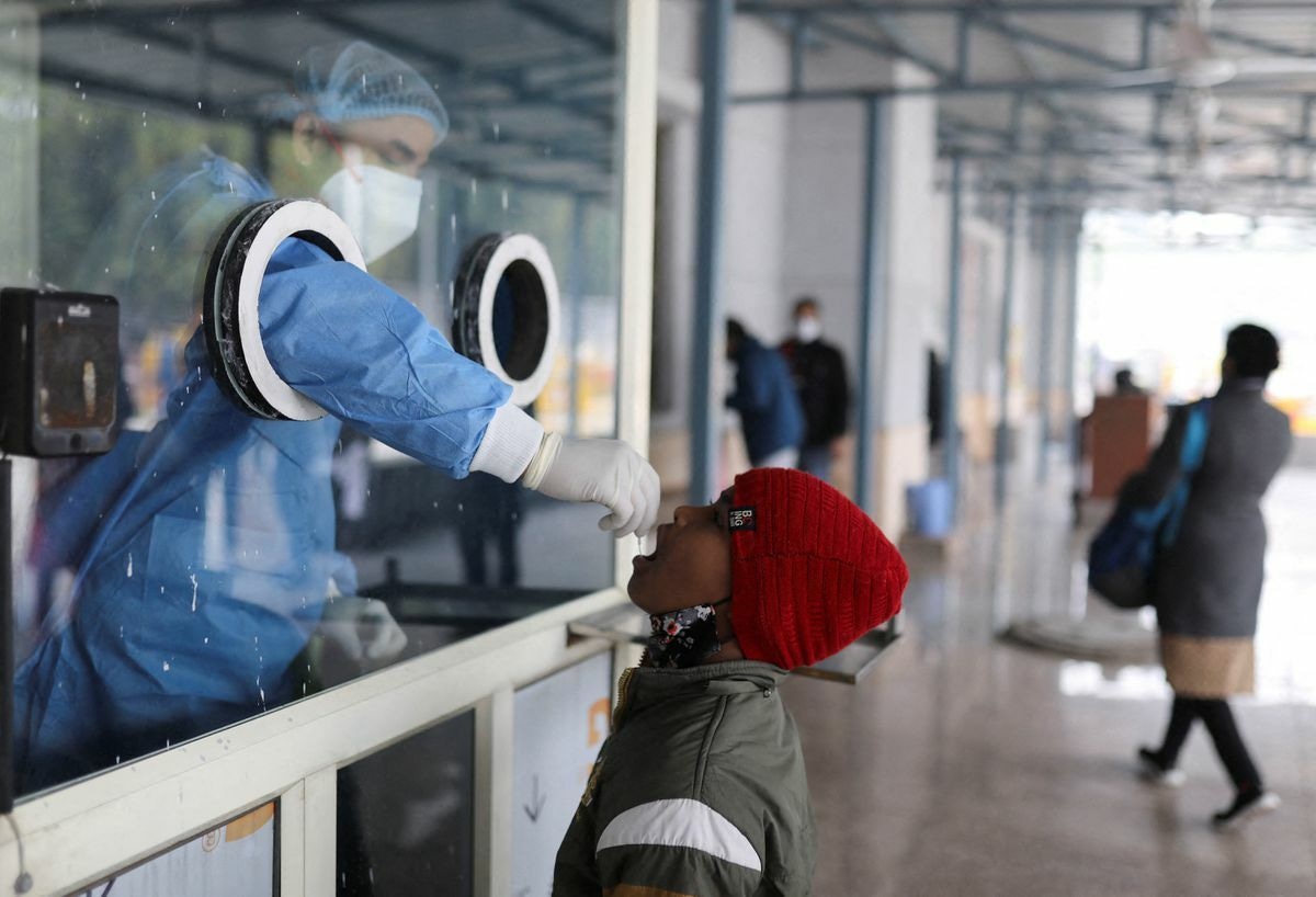 A healthcare worker collects a test swab sample from a child amidst the spread of the coronavirus at a testing centre inside a hospital in New Delhi, India, January 14. &mdash; Reuters