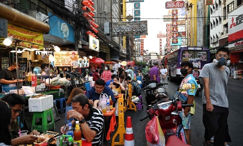 In this photo taken on January 16, people eat at roadside food stalls in the Chinatown area of Bangkok. — AFP