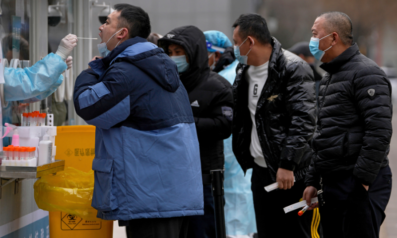 A man gets a throat swab for the Covid-19 test at a mobile coronavirus testing facility a residential area in Beijing on Wednesday. &mdash; AP