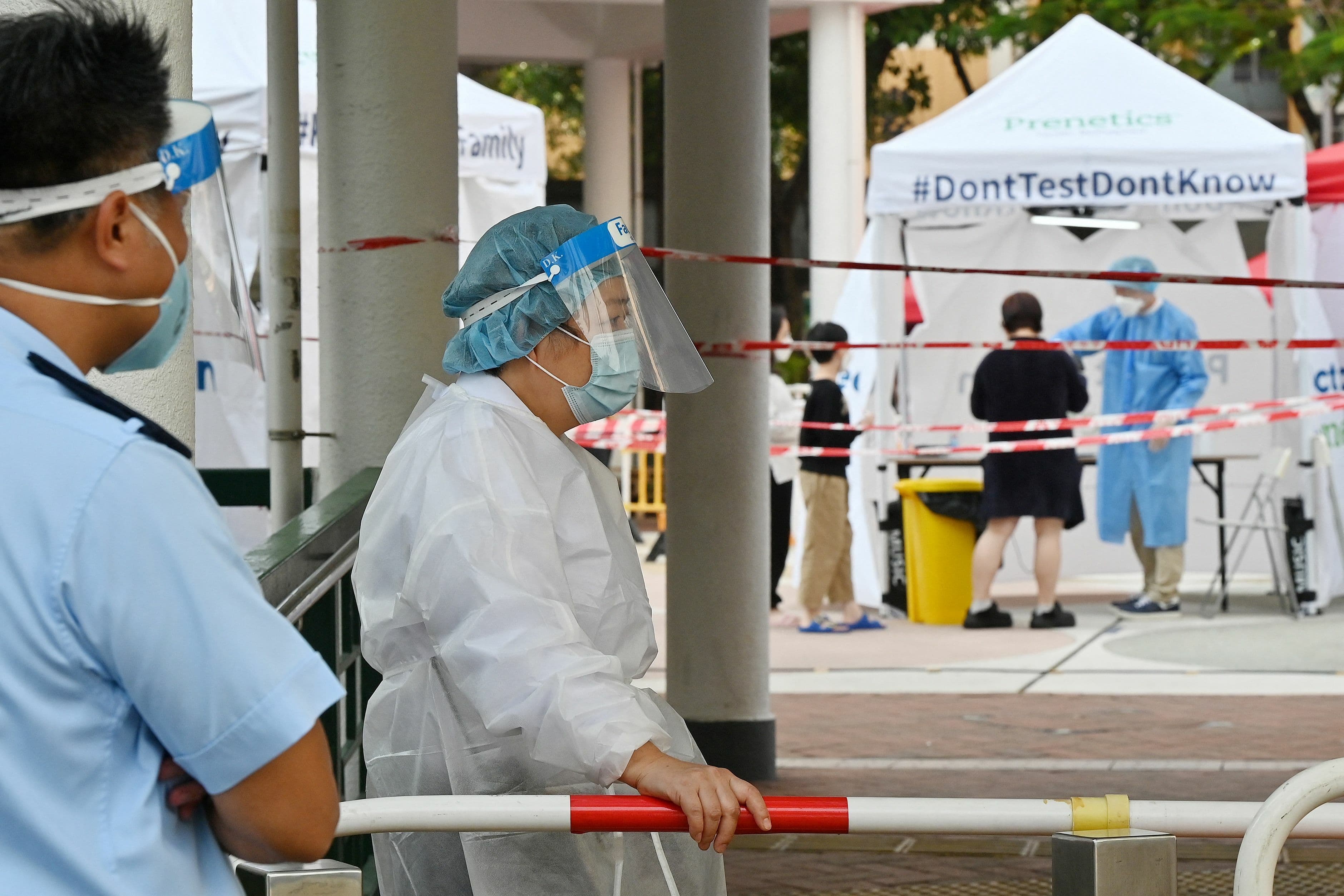 Officials in protective closing work at a Covid-19 testing station following a recent cluster of coronavirus cases, at the Kwai Chung housing estate in Hong Kong on January 27. — AFP