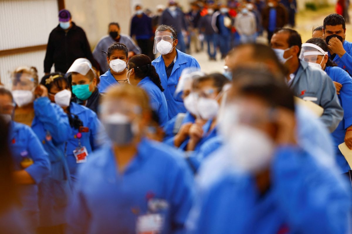 Employees of an assembly factory wait for a bus after receiving a booster shot of the AstraZeneca coronavirus vaccine during a mass vaccination programme for people over 50 years, in Ciudad Juarez, Mexico, February 1. — Reuters