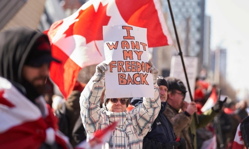 A demonstrator holds a sign during a protest against mandates related to Covid-19 vaccines and restrictions in downtown Toronto on Feb 5. — AFP
