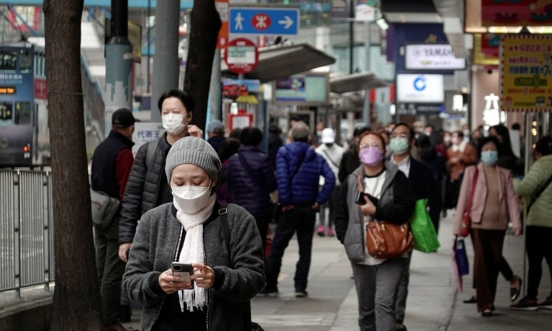 Pedestrians wearing face masks following Covid-19 outbreak walk on a street at Causeway Bay district in Hong Kong on February 9. &mdash; Reuters