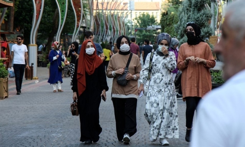 People wearing protective face masks walk along a street amid a surge in Covid-19 cases in Turkey. &mdash; Reuters