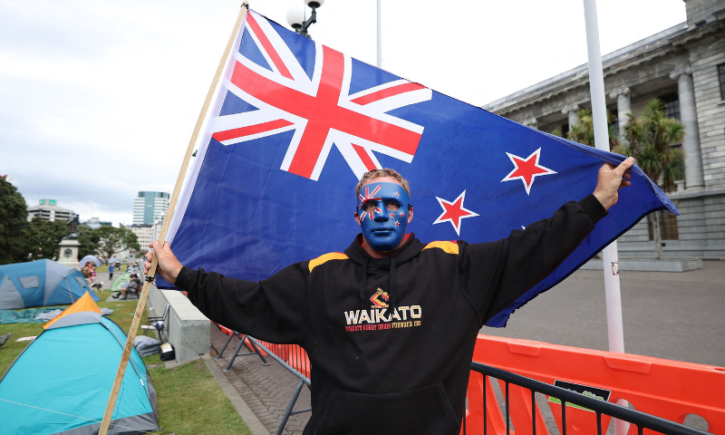 A protester with a New Zealand flag stands in front of Parliament buildings on the fourth day of demonstrations against Covid-19 restrictions, inspired by a similar demonstration in Canada, in Wellington on February 11. &mdash; AP