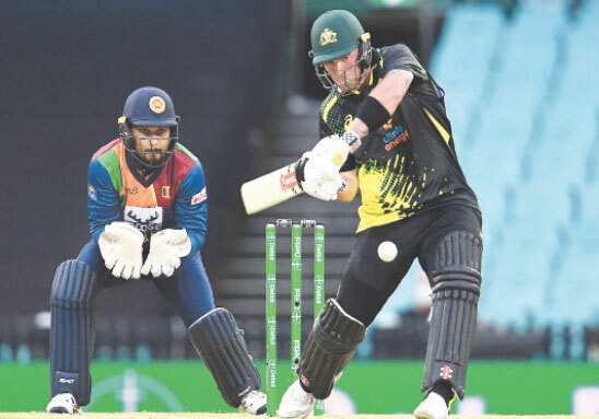AUSTRALIAN opener Ben McDermott eyes a shot as Sri Lankan wicket-keeper Dinesh Chandimal looks on during the first T20 International at the SCG on Friday.&mdash;AFP