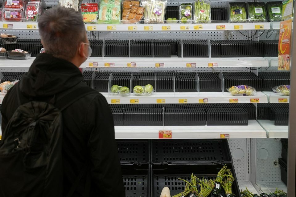 A customer wearing a facemask shops in front of partially empty shelves at a supermarket, following the outbreak of the coronavirus, at Sha Tin district, in Hong Kong, China, February 7. &mdash; Reuters