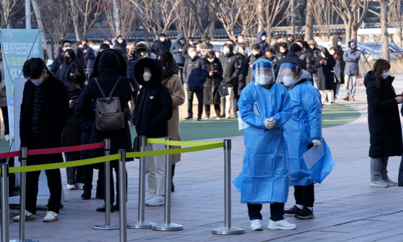 Medical workers stand by to guide people as they wait for their coronavirus test at a makeshift testing site in Seoul, South Korea on Wednesday. &mdash; AP
