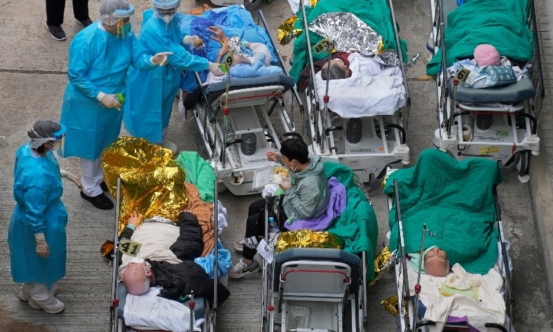 Patients lie on hospital beds as they wait at a temporary holding area outside Caritas Medical Centre in Hong Kong on February 16. &mdash; AP
