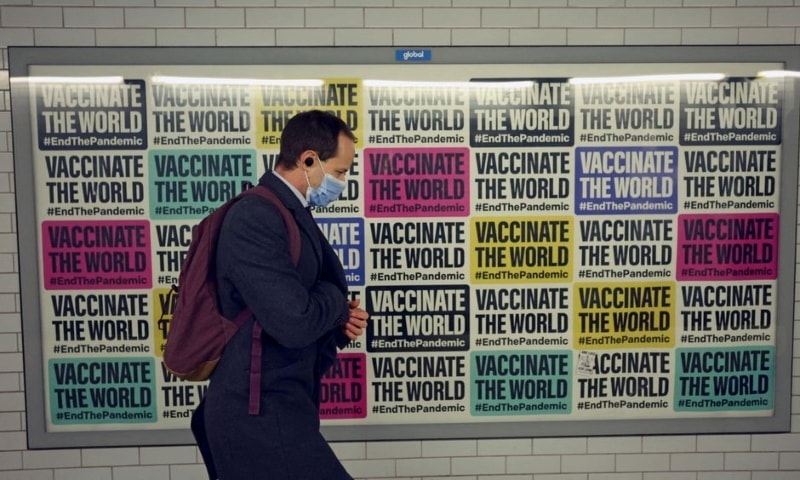 A man walks past a sign amidst the spread of Covid-19 in London on January 24. — Reuters