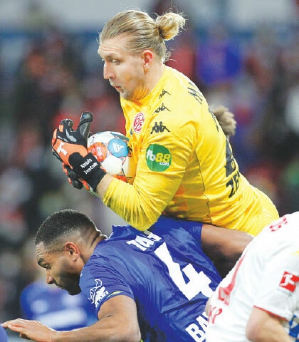 MAINZ: Mainz goalkeeper Robin Zentner (top) vies with Jonathan Tah of Bayer Leverkusen during their Bundesliga match.—AFP