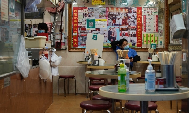 A waiter wearing a face mask waits for customers at an empty restaurant in Hong Kong on Feb 21. — AP