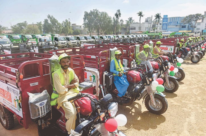 Garbage collection staff with their vehicles is standing in Shah Faisal Zone of Korangi during the inauguration ceremony of the service on Tuesday. &mdash;Fahim Siddiqi / White Star
