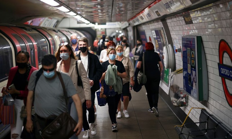 In this file photo, people, some wearing protective face masks, walk along a platform at Oxford Circus underground station in London, Britain. — Reuters/File