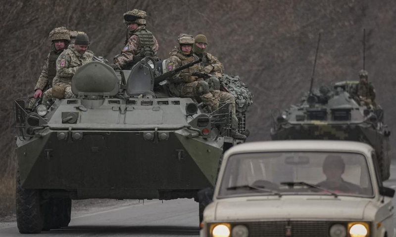 Ukrainian servicemen sit atop armoured personnel carriers driving on a road in the Donetsk region, eastern Ukraine on Thursday. — AP