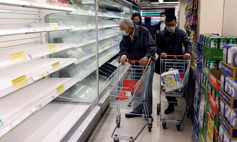 Customers wearing masks shop in front of partially empty shelves at a supermarket during the coronavirus outbreak in Hong Kong. — Reuters