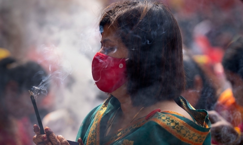 A Hindu devotee wearing a face mask as a precaution against Covid-19 offers prayers at a temple of Hindu god Shiva during Shivratri festival, in Gauhati, India on Tuesday. &mdash; AP
