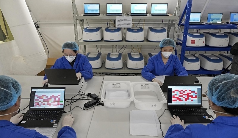 Health workers from mainland China work on test samples taken from Hong Kong residents at an inflatable mobile coronavirus testing lab in Hong Kong on Tuesday. — AP