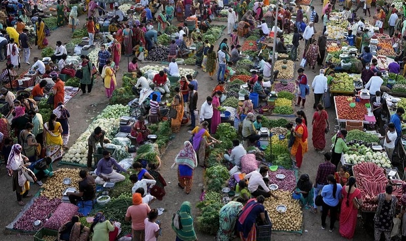 Shoppers buy produce at an open-air market in Ahmedabad, India on Thursday. &mdash; AP