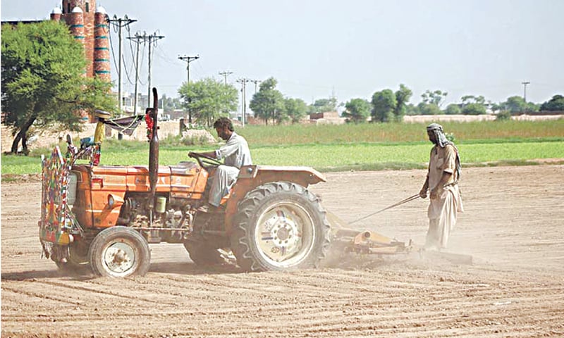 MULTAN: Farmers busy in preparing their field with the help of a tractor for the next crop.—APP