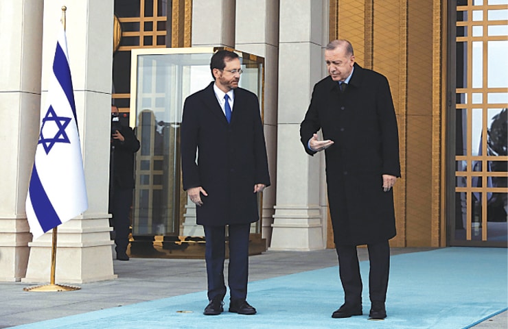 ANKARA: Turkish President Recep Tayyip Erdogan shows the way to Israeli President Isaac Herzog during a welcome ceremony on Wednesday.—AP