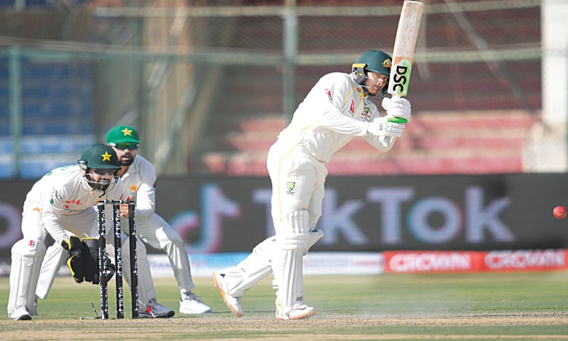 AUSTRALIAN opener Usman Khawaja plays a stroke as Pakistan captain Babar Azam and wicket-keeper Mohammad Rizwan look on during the second Test at the National Stadium on Saturday.&mdash;Tahir Jamal/White Star