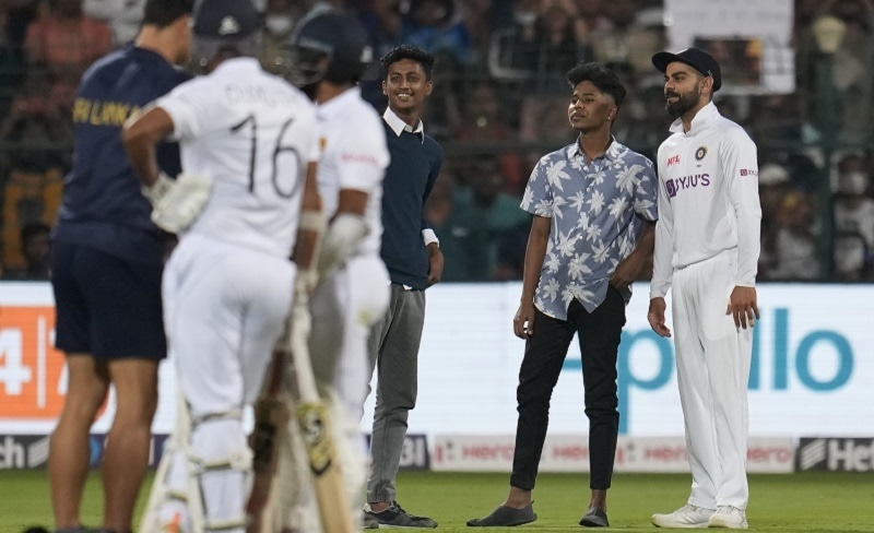 India's Virat Kohli, right, poses for a selfie with the young boys who intruded the pitch area during the second day of the second Test match between India and Sri Lanka in Bengaluru on Sunday. &mdash;AP