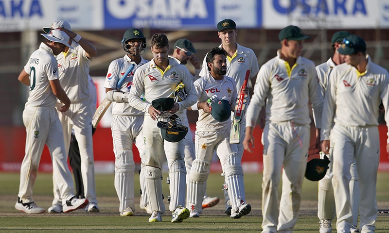 Pakistani and Australian players leave the ground at the end of the play of the second Test match between Pakistan and Australia at the National Stadium in Karachi on Wednesday. — AP