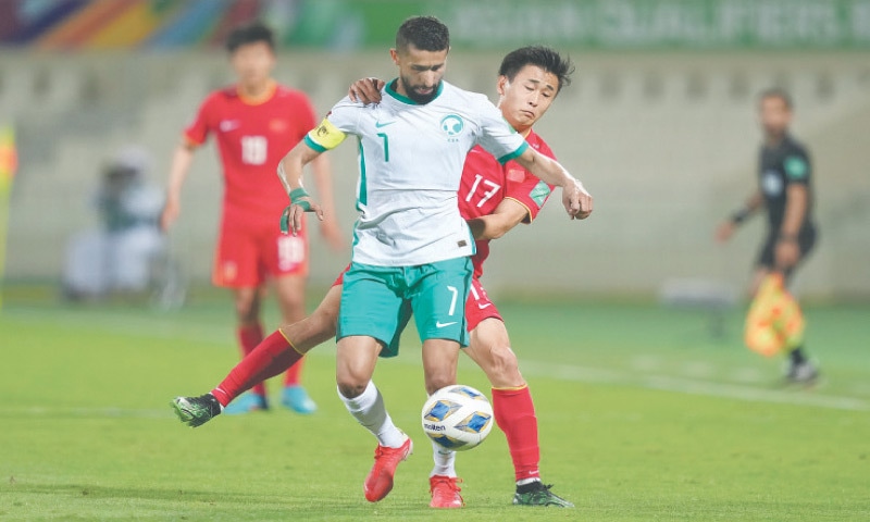 SHARJAH: Dai Wai-Tsun (behind) of China challenges Saudi Arabia’s Salman Alfaraj during their World Cup qualifier on Thursday.—AP