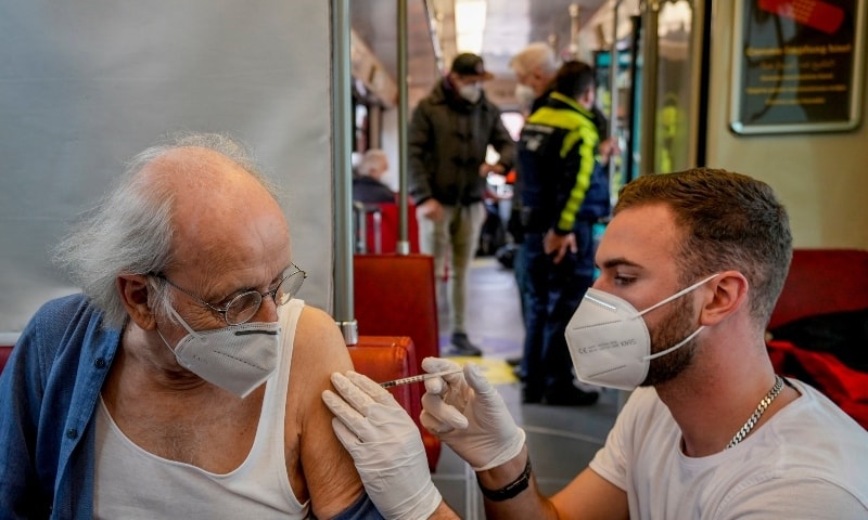 This file photo shows a 85-year-old man receiving a booster vaccination in the so called “vaccination express” tram in central Frankfurt, Nov 4, 2021.