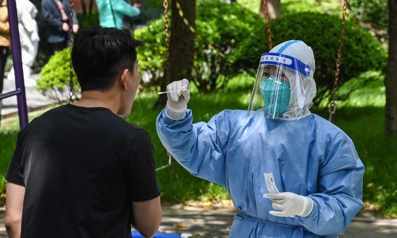 A health worker conducts a swab test for Covid-19 at a residential compound during the second stage of a pandemic lockdown in Jing', a district in Shanghai, on April 6. — AFP