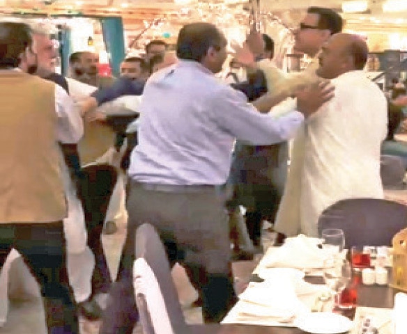 A video grab shows a PTI supporter scuffling with Nadeem Afzal Chan and Noor Alam Khan at a local hotel in Islamabad on Tuesday.