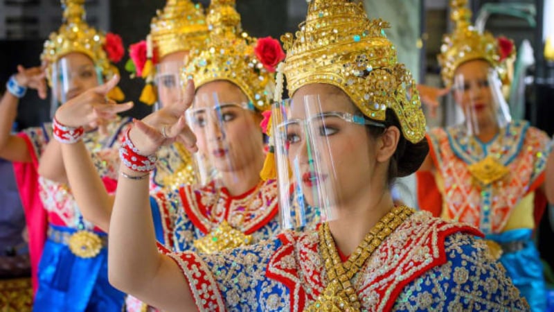 Traditional Thai dancers wearing protective face shields perform at Bangkok's Erawan Shrine, which was reopened after the Thai government relaxed measures to combat the spread of Covid-19 on May 4.—AFP