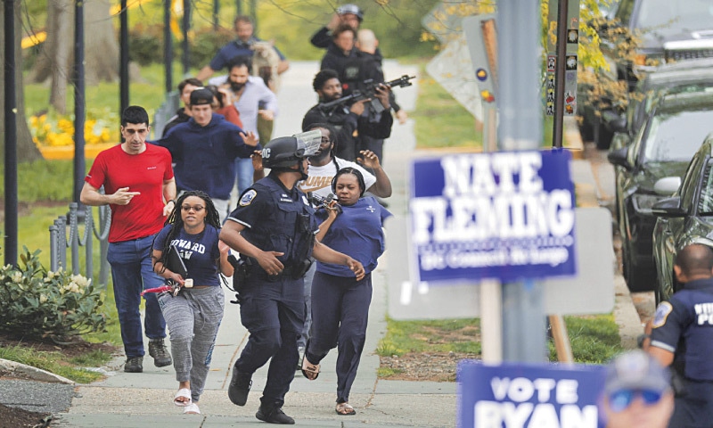 WASHINGTON: Metropolitan Police escort people away from a shooting scene in the northwest part of the city.&mdash;AFP