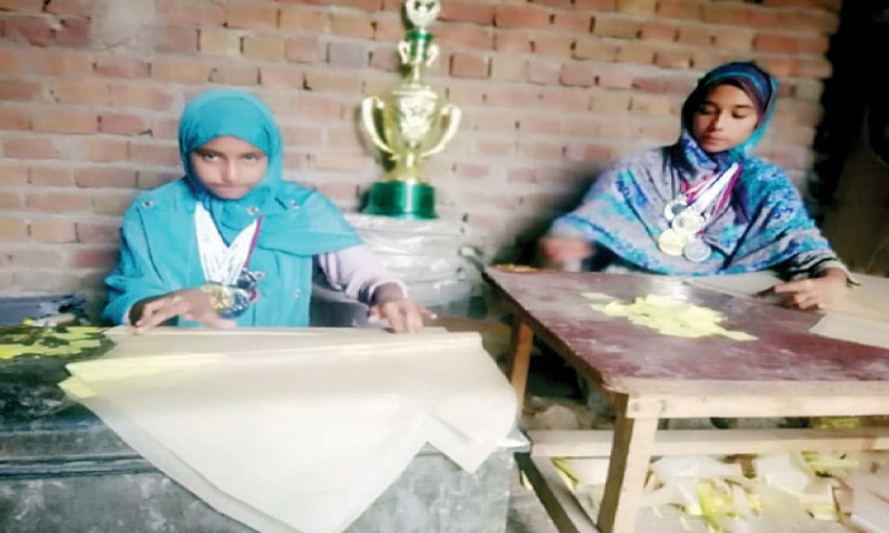 Husna and Hafsa make kites at their home. &mdash; Dawn